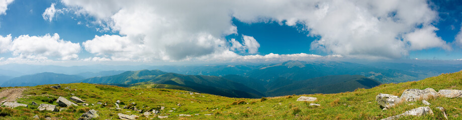 Fototapeta na wymiar mountain panorama on a sunny day. beautiful nature background. gorgeous cloudscape above the mountain ridge with grassy meadows. travel back country concept