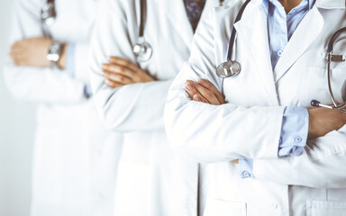 Group of modern doctors standing as a team with arms crossed in hospital office and ready to help patients. Medical help, insurance in health care, best disease treatment and medicine concept