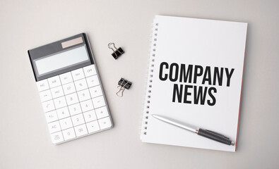 The word Company News is written on a white background next to a pen ,calculator and reports. Business concept