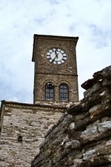Tower clock of old fortress on background of cloudy sky