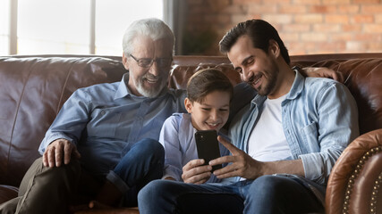 Happy family three generations, kid, dad, grandpa meeting at home, enjoying leisure time together,...