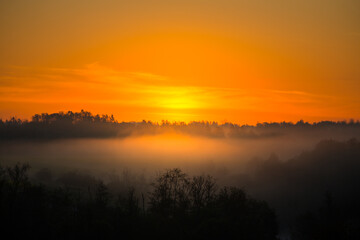 A misty sunrise landscape over the small river valley. Summertime scenery of Northern Europe.