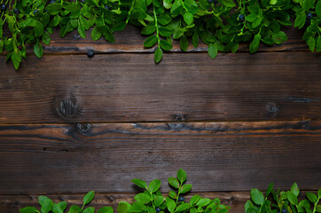 wooden background with twigs and berries of blueberries and space for text