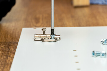 Installing furniture door hinges, fittings, assembling furniture process with screwdriver
