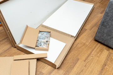 cardboard box with fittings in packets for furniture assembly at home