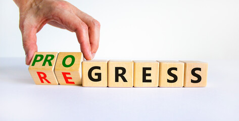 Regress or progress symbol. Businessman turns wooden cubes and changes the word 'regress' to...