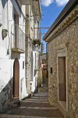 Fototapeta premium A narrow street between the old houses of Sant'Agata di Puglia, a medieval village in southern Italy.