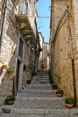 Fototapeta na wymiar A narrow street between the old houses of Sant'Agata di Puglia, a medieval village in southern Italy.