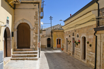 Obraz premium A narrow street between the old houses of Sant'Agata di Puglia, a medieval village in southern Italy.