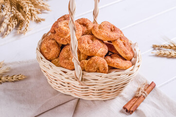 Fresh tasty cookies with cinnamon in a wicker basket on a wooden background