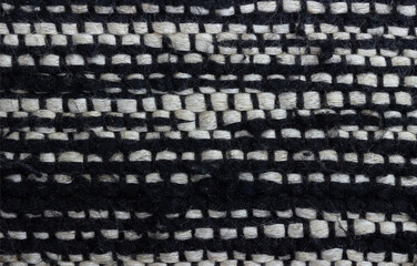 Black and white wool weave material. Fabric textured background with copy space. Top view