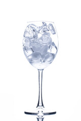 Wine glass full of ice cubes on white 