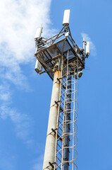 Telecommunication tower for mobile phone with antennas over a blue sky
