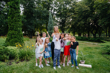 Fototapeta premium A teacher teaches a class of children in an outdoor Park. Back to school, learning during the pandemic