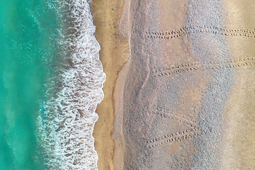 Fototapeta na wymiar Turtle footprints leading from sea across one of Cyprus sandy beaches, aerial shot directly above