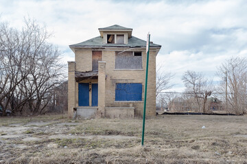 Single lonely house left abandoned in urban Detroit neighborhood on cloudy day