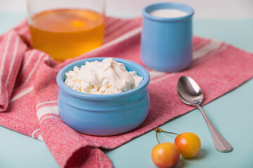 Cottage cheese in a blue bowl with sour cream and honey. Morning breakfast.