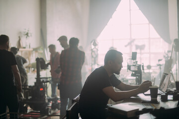 Fototapeta premium Editing director behind monitors on the set. A video editor edits video online while filming for a playback.