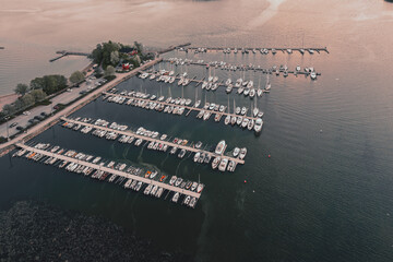 Aerial top view of a lot of white yachts and sailboats moored in a marina, summer season