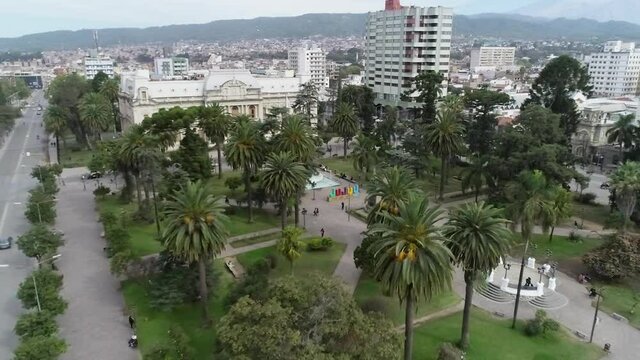 Alejandoce de la plaza central de jujuy argentina, mostrando la casa de gobierno, parte de la ciudad y los bellos cerros de colores en el horizonte.