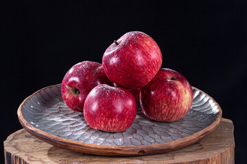 Fototapeta na wymiar red apples on a beautiful plate on a black background