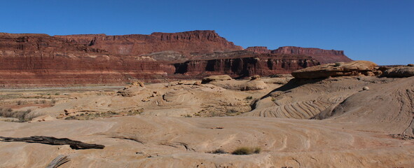 Pinkish-white ancient sandstone dunes with towering ancient red limestone reefs; glen canyon, southeast utah