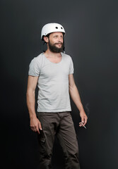 American handsome bearded man in a bicycle helmet. safety device for protect health. Serious Russian Man Smoking Cigarette. Sport and harmful habit. Smoking causes lung cancer and other diseases.