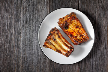grilled pork ribs on a plate, top view