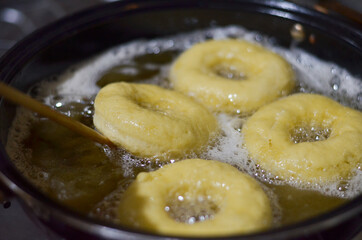 frying donuts in hot oil in a frying pan