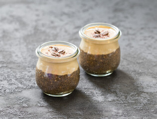 Coffee pudding chia seeds with cottage cheese cream in a jar on a dark gray background