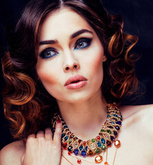 Fototapeta premium beauty rich woman with bright makeup wearing luxury jewellery on black background, fashion lady curly hairstyle