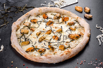 Tasty sliced pizza with seafood and tomato on black background