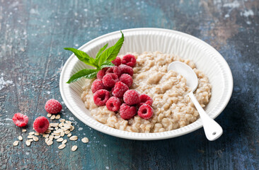 Breakfast gluten free oatmeal porridge with raspberries in a white bowl. Healthy breakfast concept.