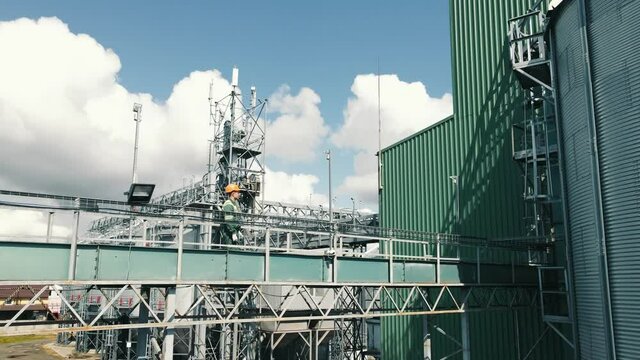 The production engineer goes over the metal structures and inspects the plant. An employee of a large enterprise walking on the territory