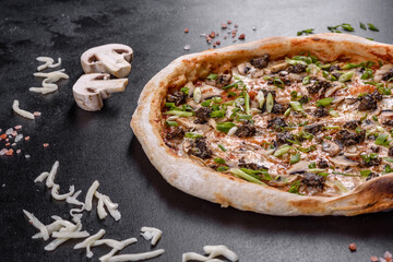 Fresh delicious Italian pizza with meat, mushrooms and tomatoes on a dark concrete background