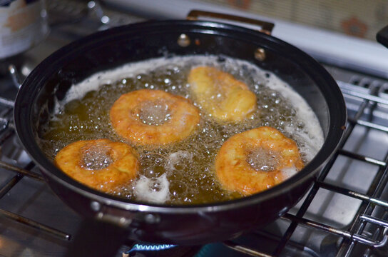 frying donuts in hot oil in a frying pan