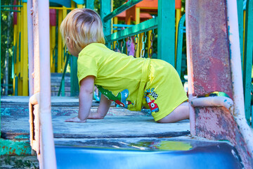 Baby's first steps on the playground. bridge of wooden boards