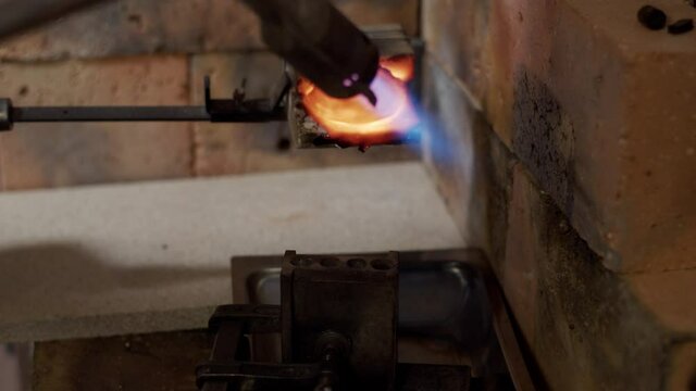 Melting gold into liquid form for jewellery at a smith's workshop.