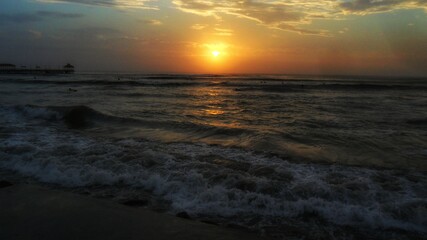 The colorful sunset ocean beach with deep chlorine sky and sun rays.
