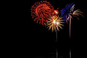 Holiday fireworks above water with reflection in the water