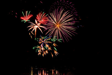 Holiday fireworks above water with reflection in the water