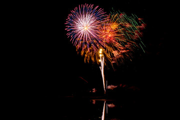 Holiday fireworks above water with reflection in the water