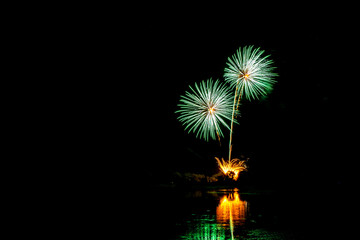 Fototapeta premium Holiday fireworks above water with reflection in the water