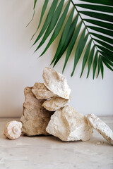 Empty Podium Stones tower. Gray stones pedestal display on beige background made from seashell...