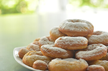 pile of donuts with powdered sugar topping with beautiful blurred background