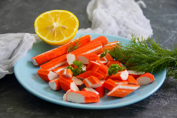 crab sticks, lemon on concrete background