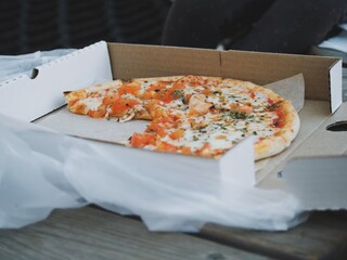 
child eating takeaway pizza with dad on the street