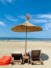 Two lounge chairs with sun umbrella on a beach in Durres,Albania