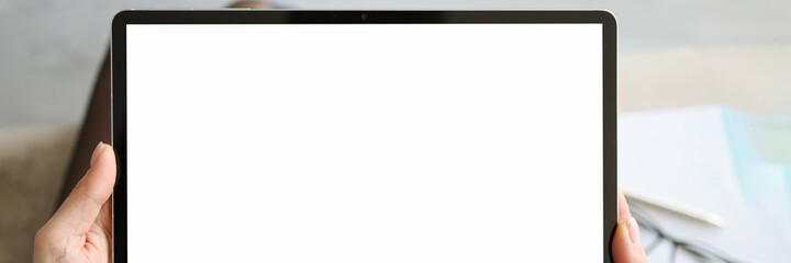 Woman holding tablet with white screen in her hands closeup