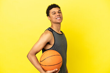 Obraz premium African American man isolated on yellow background playing basketball